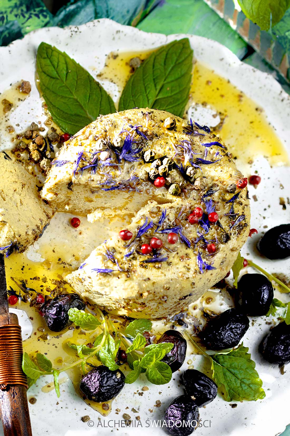WEGAŃSKA FETA SŁONECZNIKOWA NA&nbsp;SUROWO Z&nbsp;OLIWĄ, MIĘTĄ, MELISĄ, PŁATKAMI BŁAWATKA, OLIWKAMI KALAMATA, ZIELONYM I&nbsp;CZERWONYM PIEPRZEM